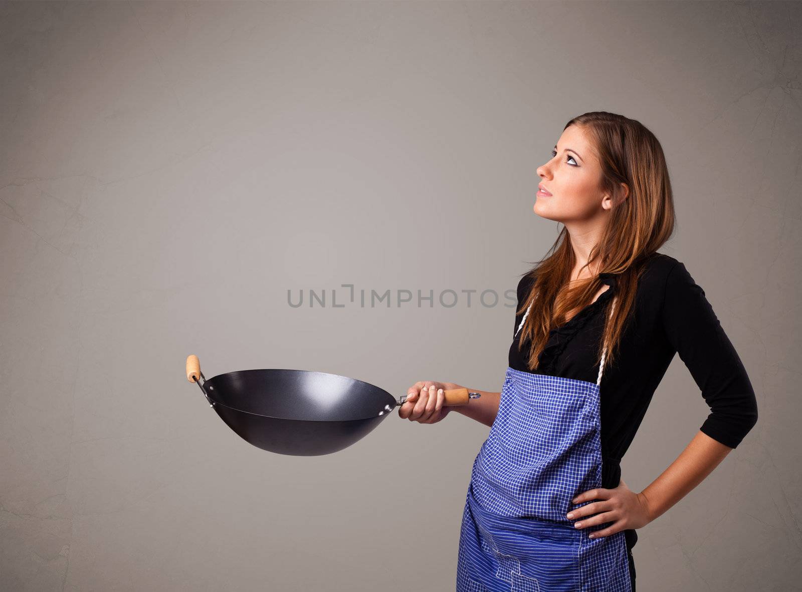 Attractive young lady holding a frying pan