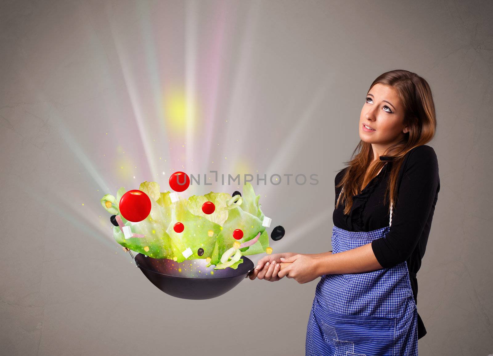 Beautiful young woman cooking fresh vegetables with abstract lights