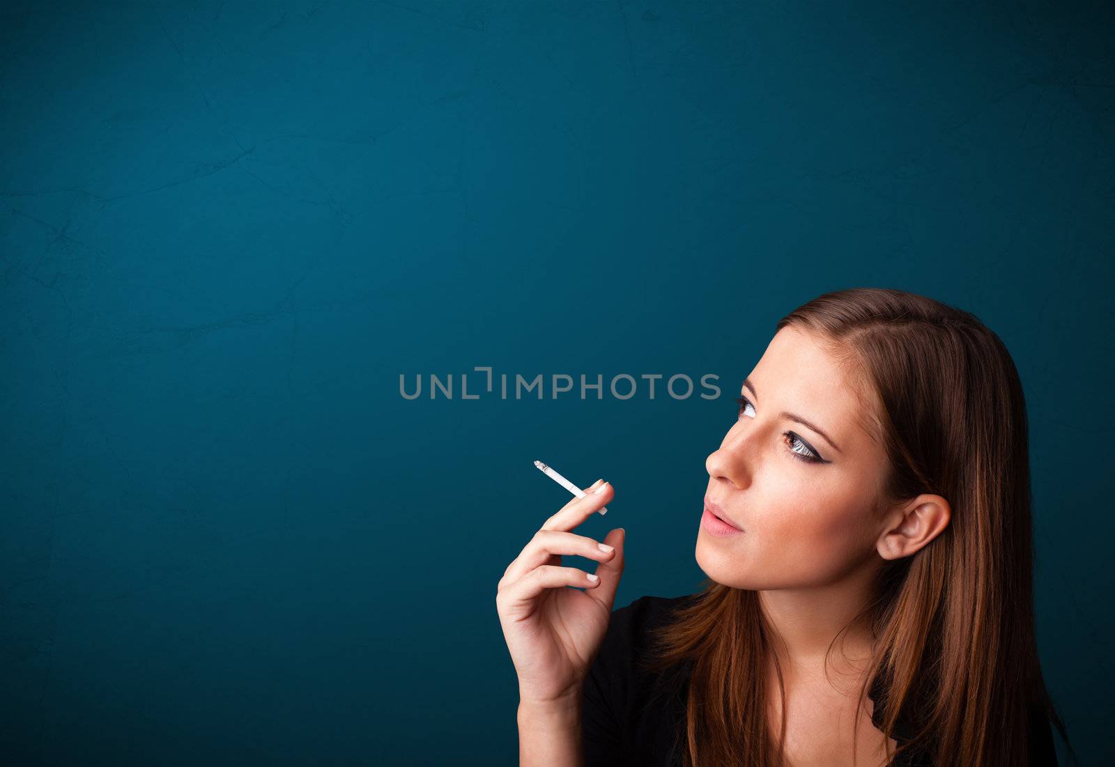 Beautiful woman smoking cigarette vith copy space by ra2studio