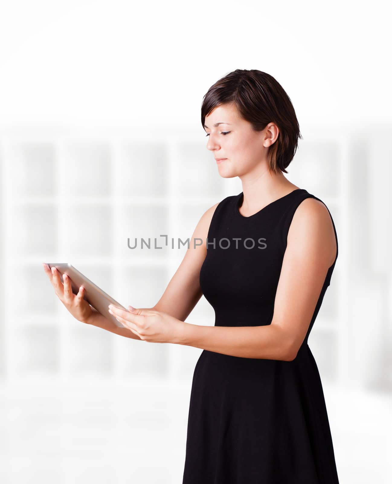 Young woman looking at modern tablet by ra2studio