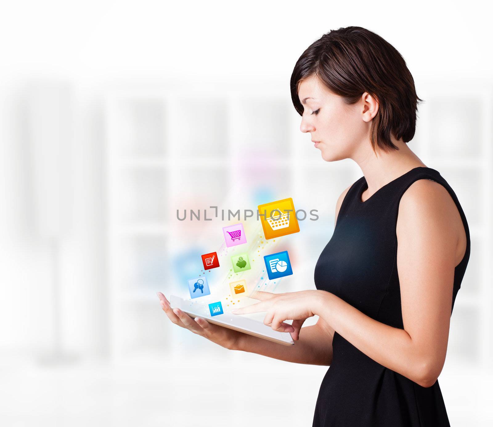 Young woman looking at modern tablet with colourful icons by ra2studio