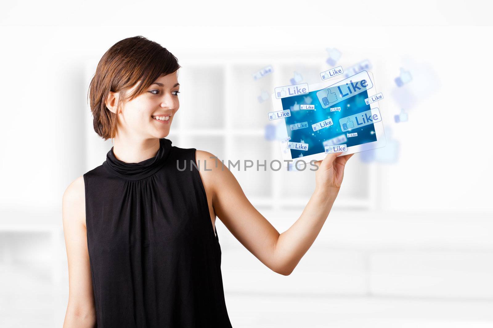 Young woman looking at modern tablet with social icons by ra2studio