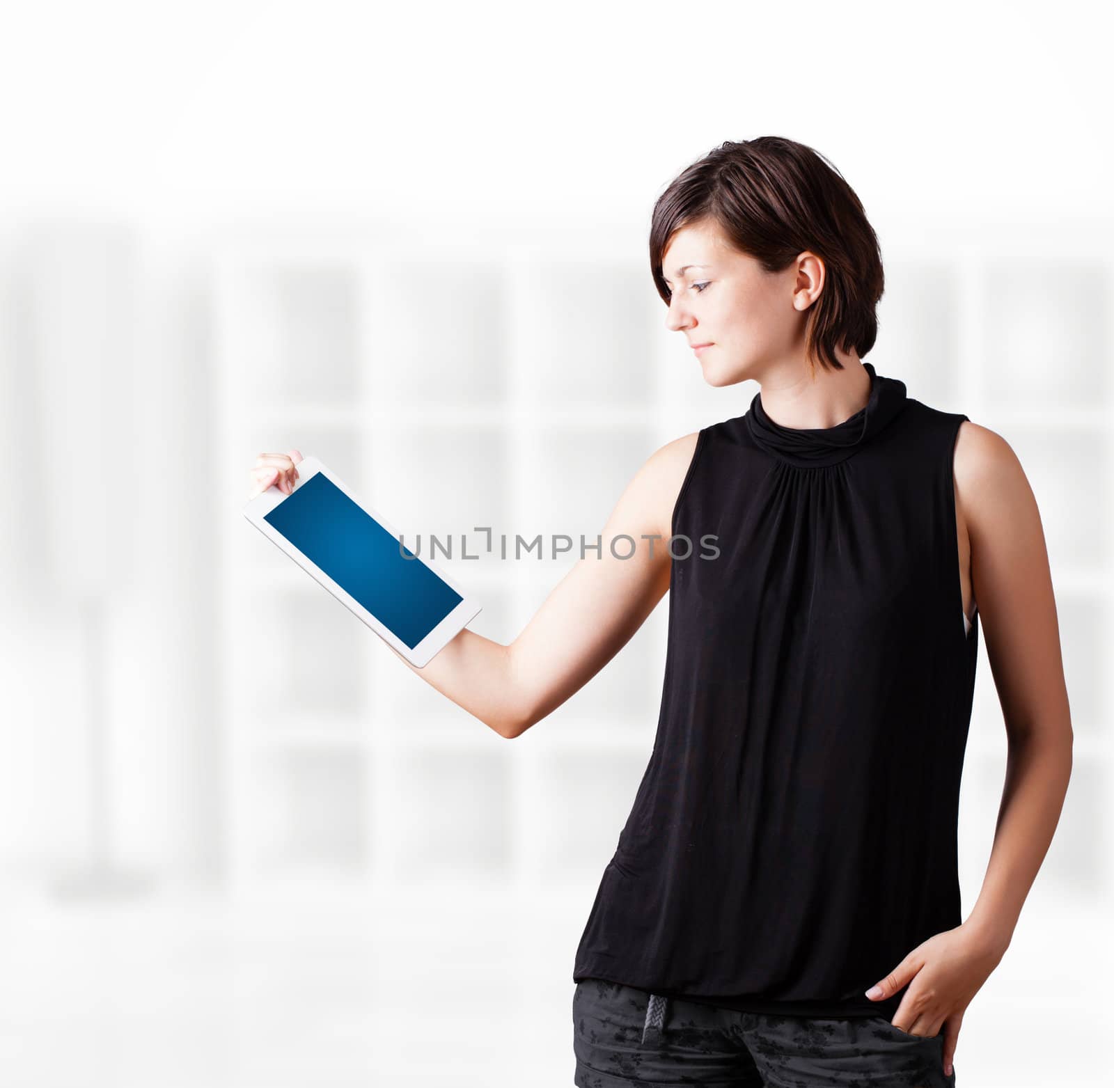 Young woman looking at modern tablet by ra2studio