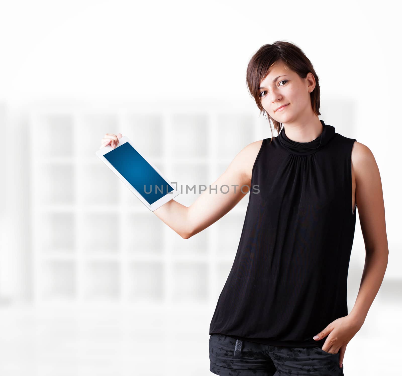 Young woman looking at modern tablet by ra2studio