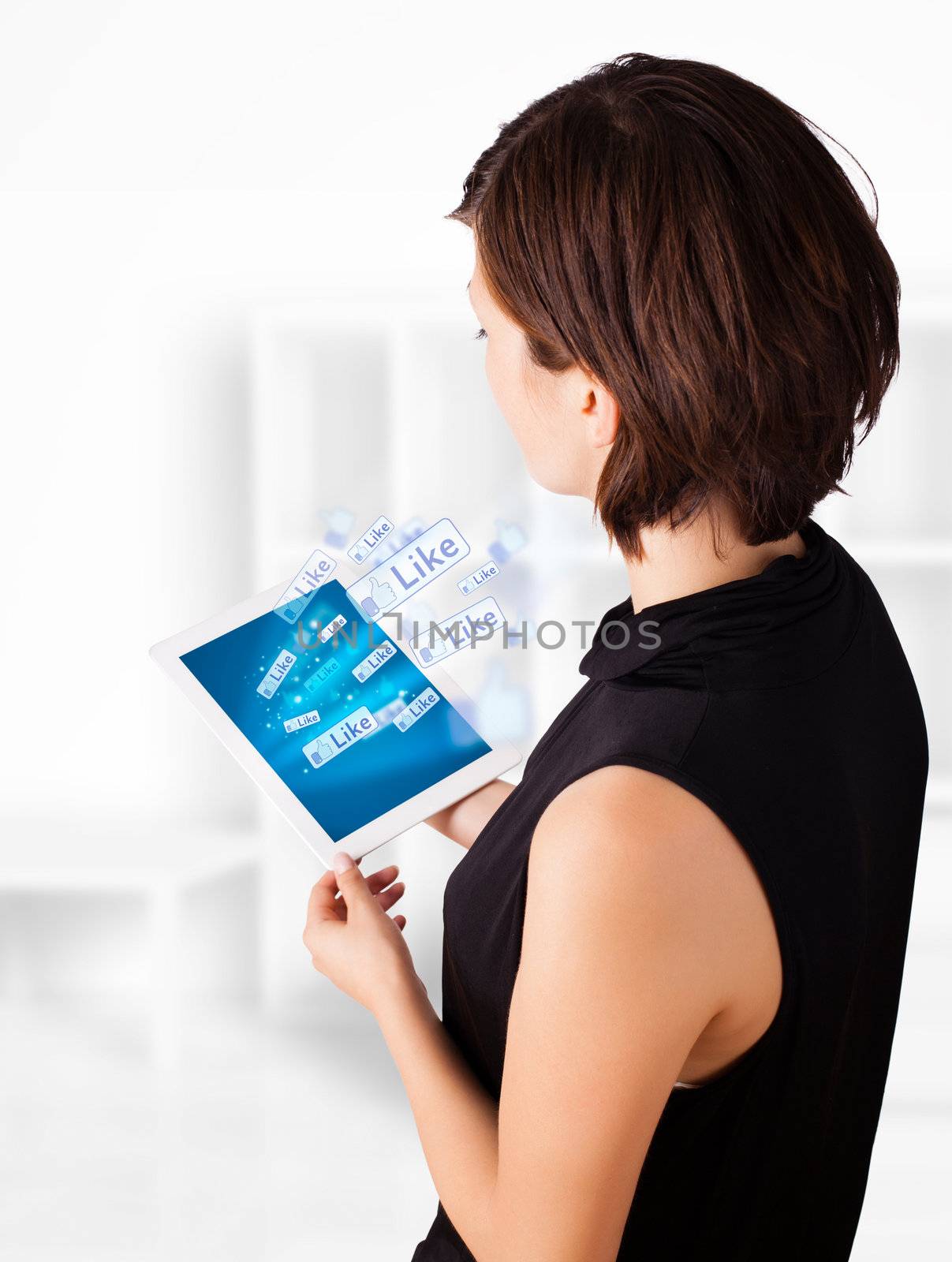 Young business woman looking at modern tablet with social icons