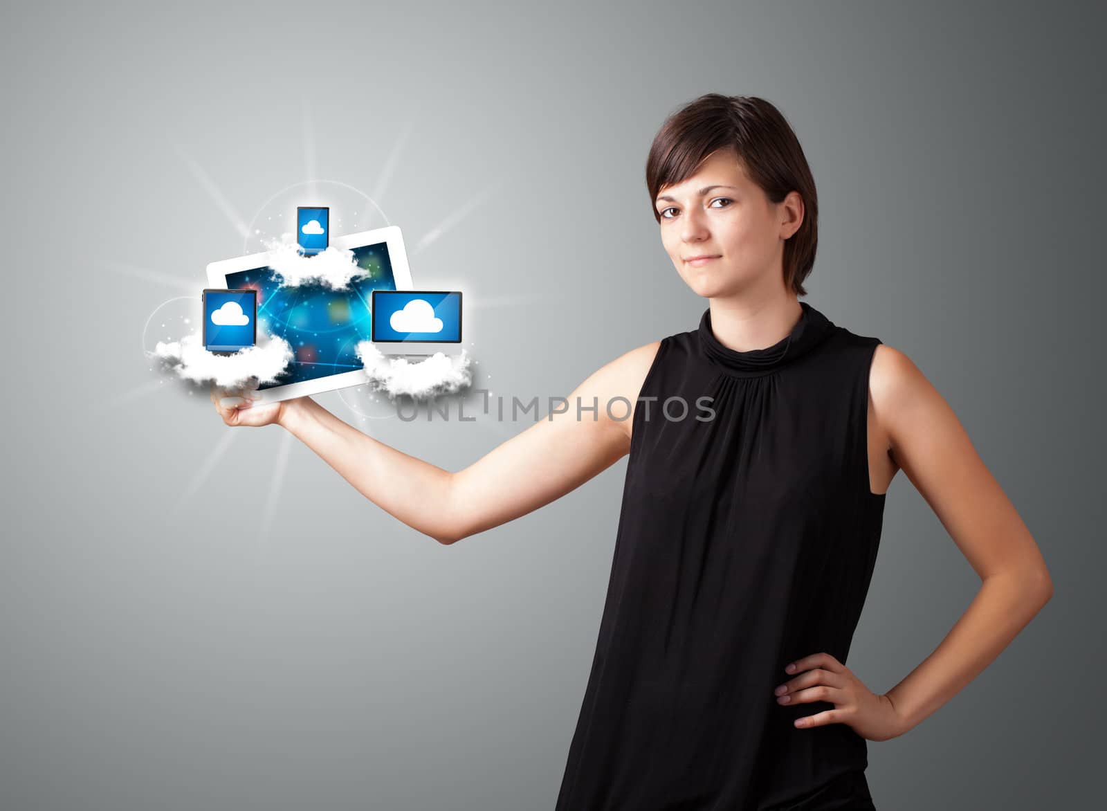 Beautiful young woman holding tablet with modern devices in clouds