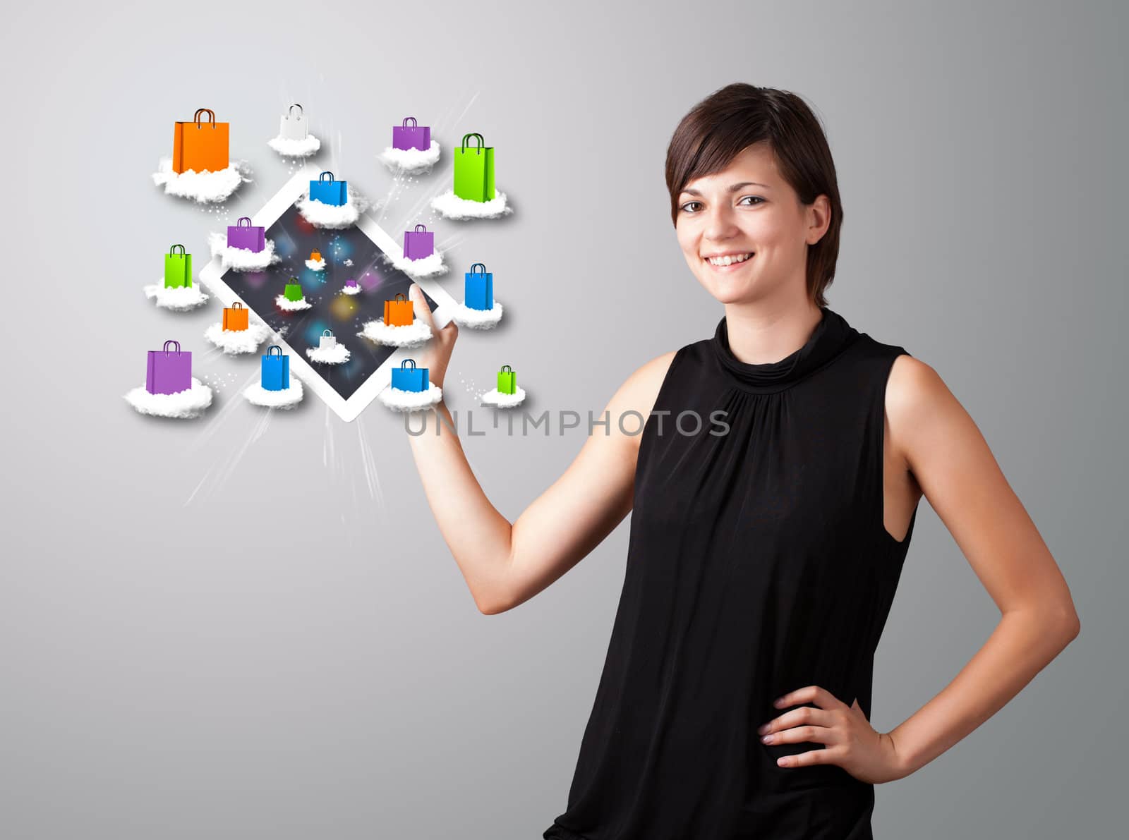 beautiful woman holding modern tablet with colorful shopping bags on clouds