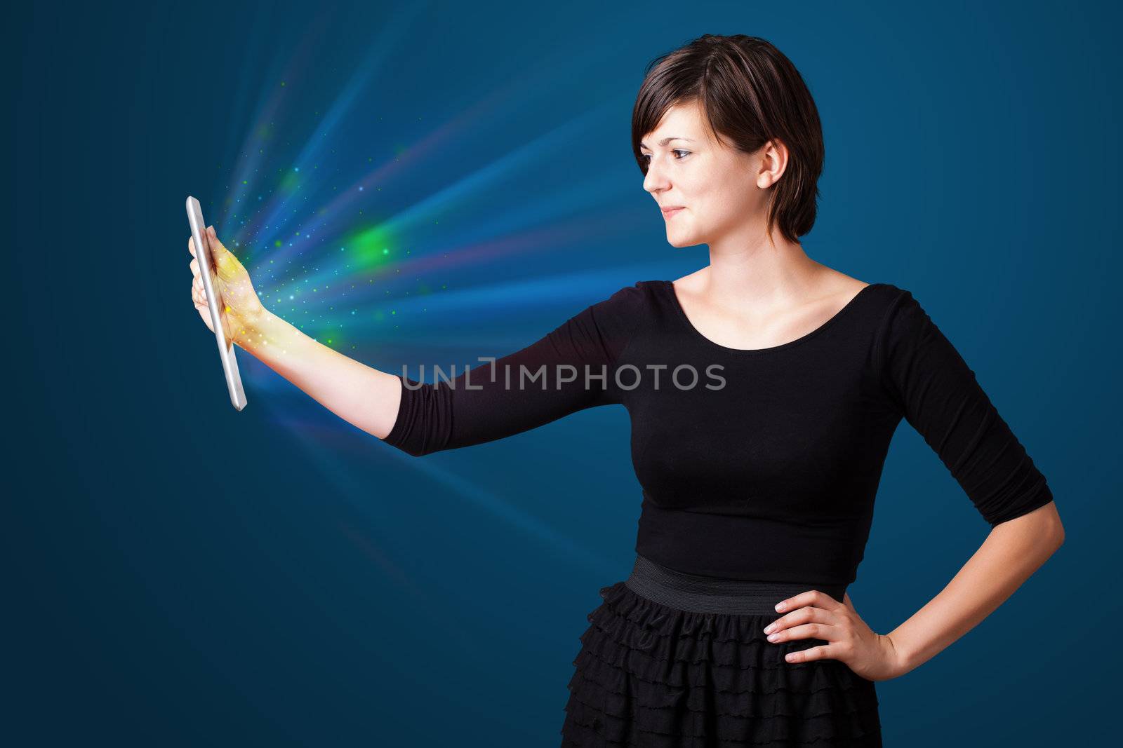 Young business woman looking at modern tablet with abstract lights 