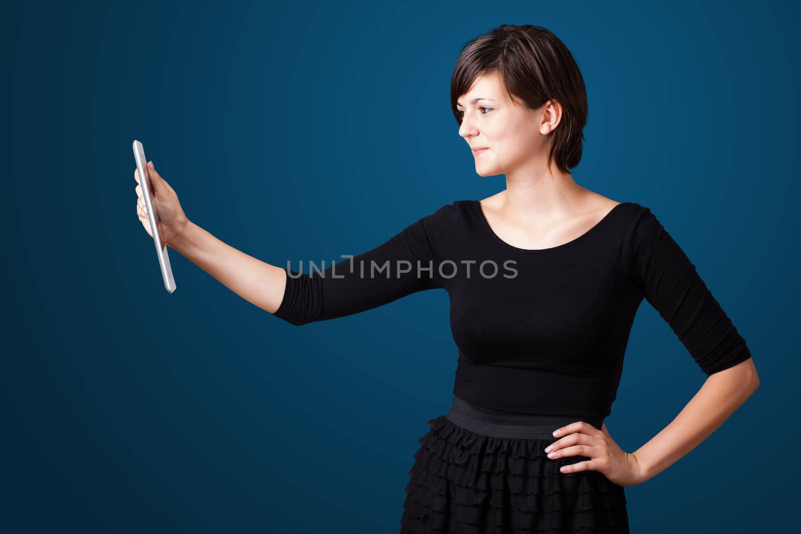 Young woman looking at modern tablet by ra2studio