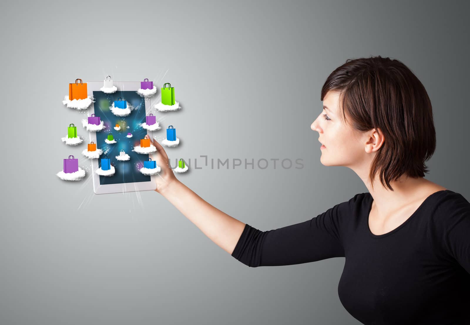 beautiful woman holding modern tablet with colorful shopping bags on clouds