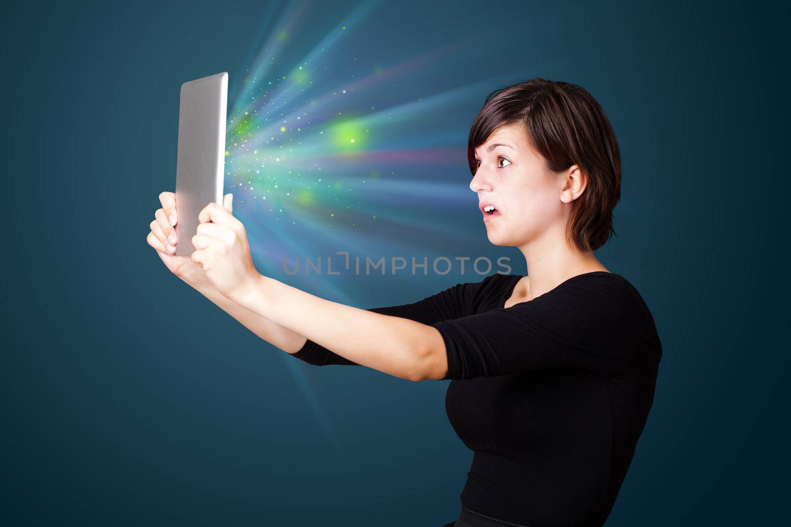 Young business woman looking at modern tablet with abstract lights 