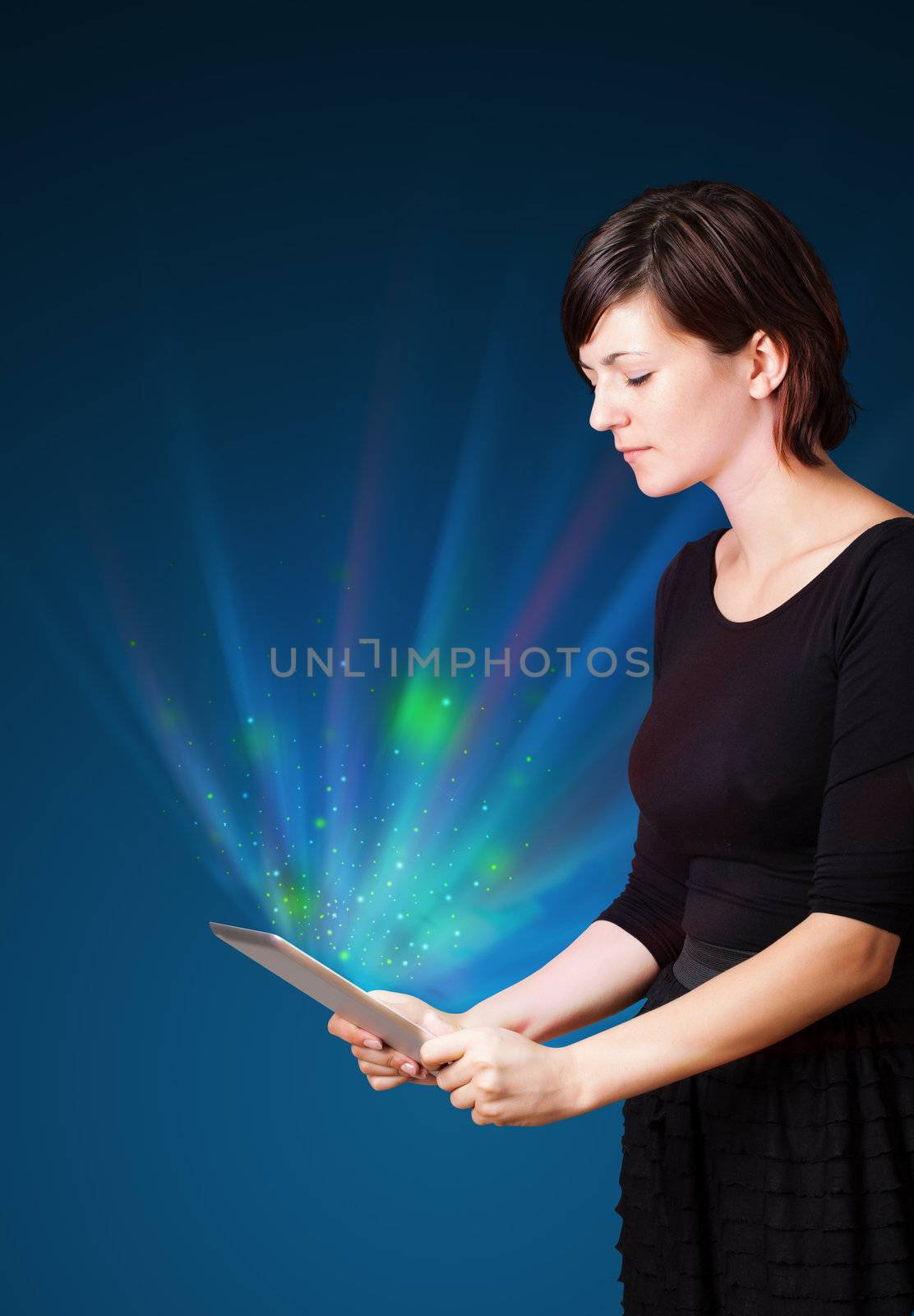 Young business woman looking at modern tablet with abstract lights 