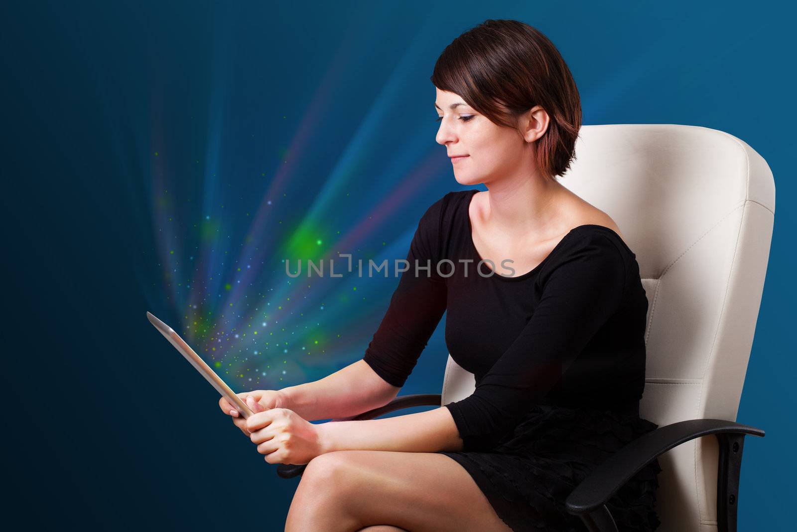 Young business woman looking at modern tablet with abstract lights 