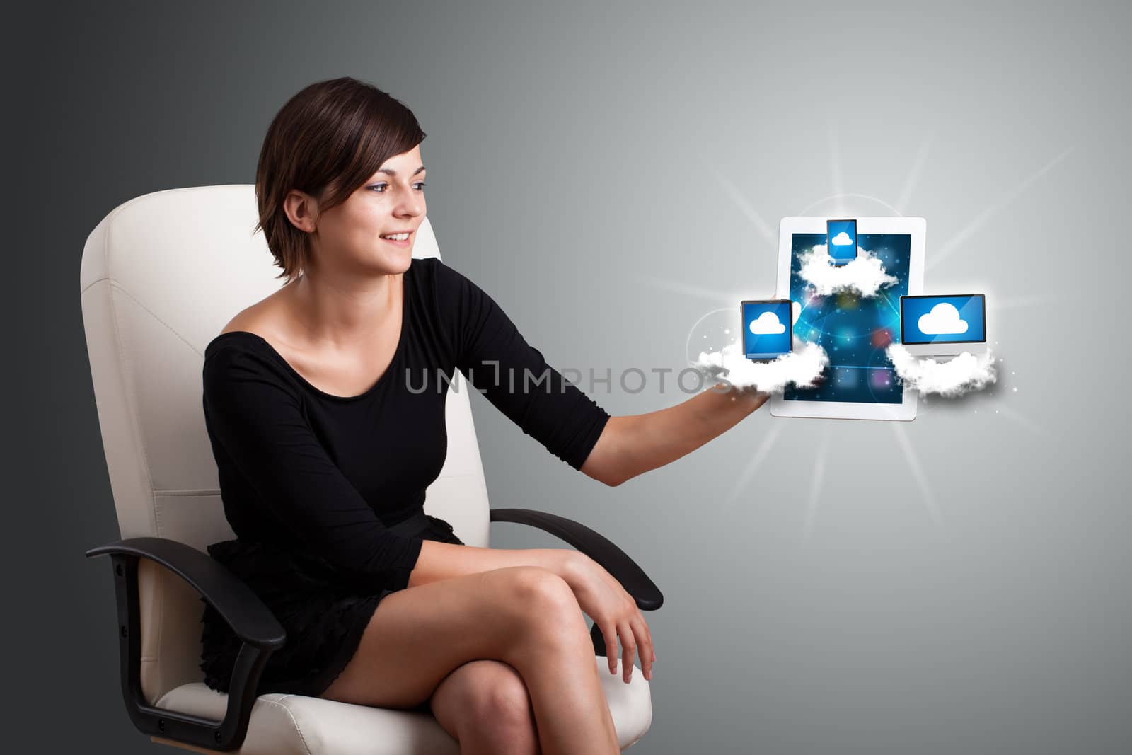 Beautiful young woman holding tablet with modern devices in clouds