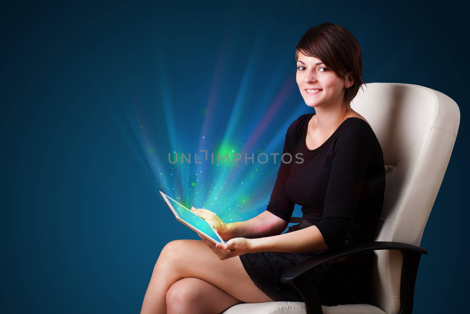Young woman looking at modern tablet with abstract lights  by ra2studio