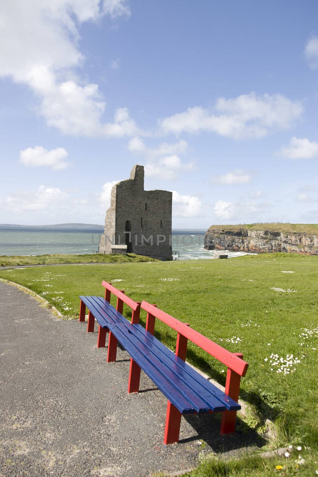 Beautiful view over the Ballybunion castle beach castle and cliffs in Ireland with wooden benches