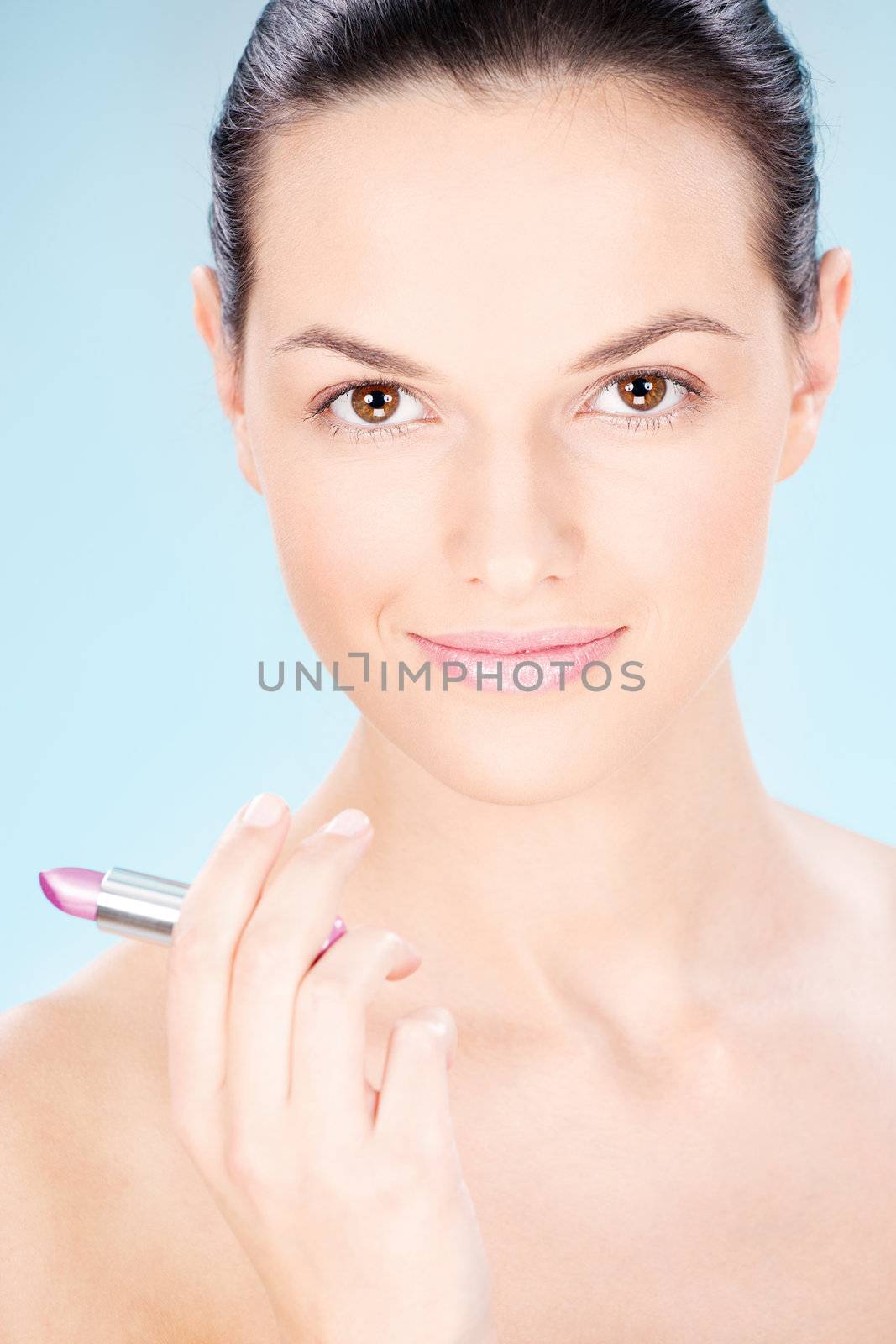 Pretty woman holding lipstick