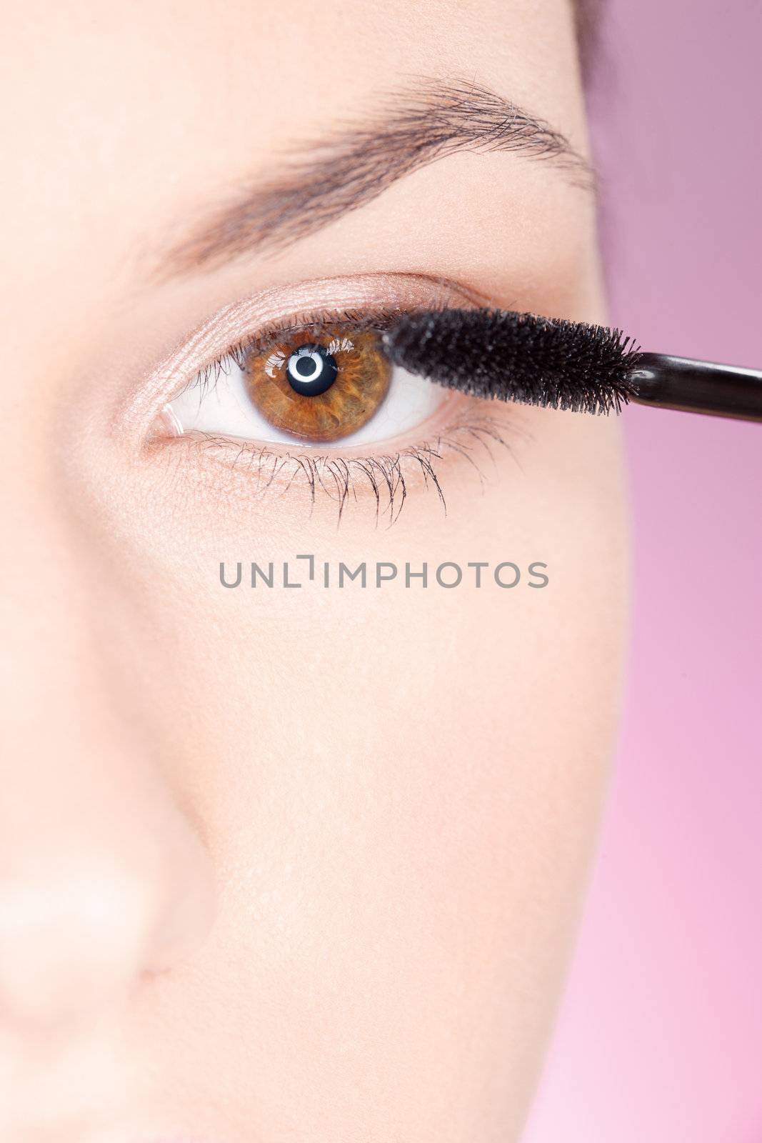 Close up of a woman applying mascara on eye