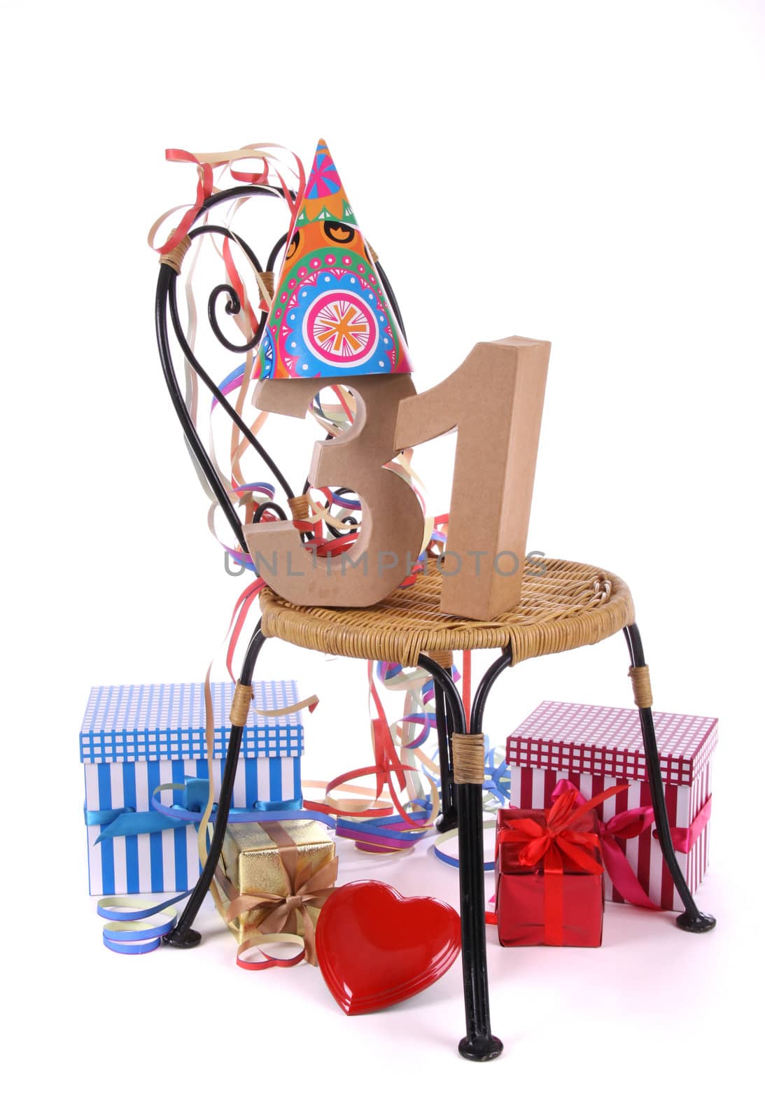 Number of age in a colorful studio setting with paper party hat and figures, a red heart and gifts