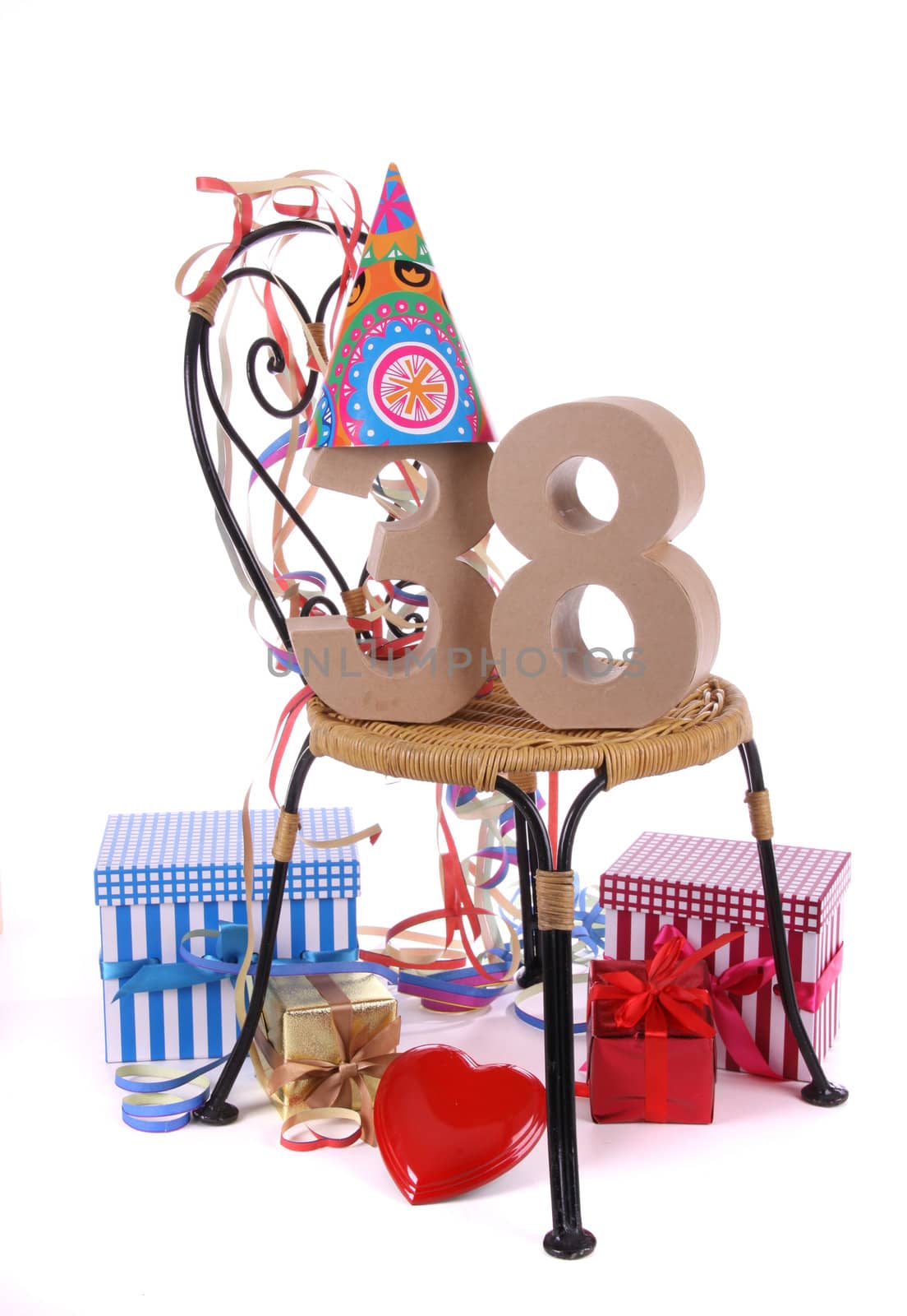 Number of age in a colorful studio setting with paper party hat and figures, a red heart and gifts