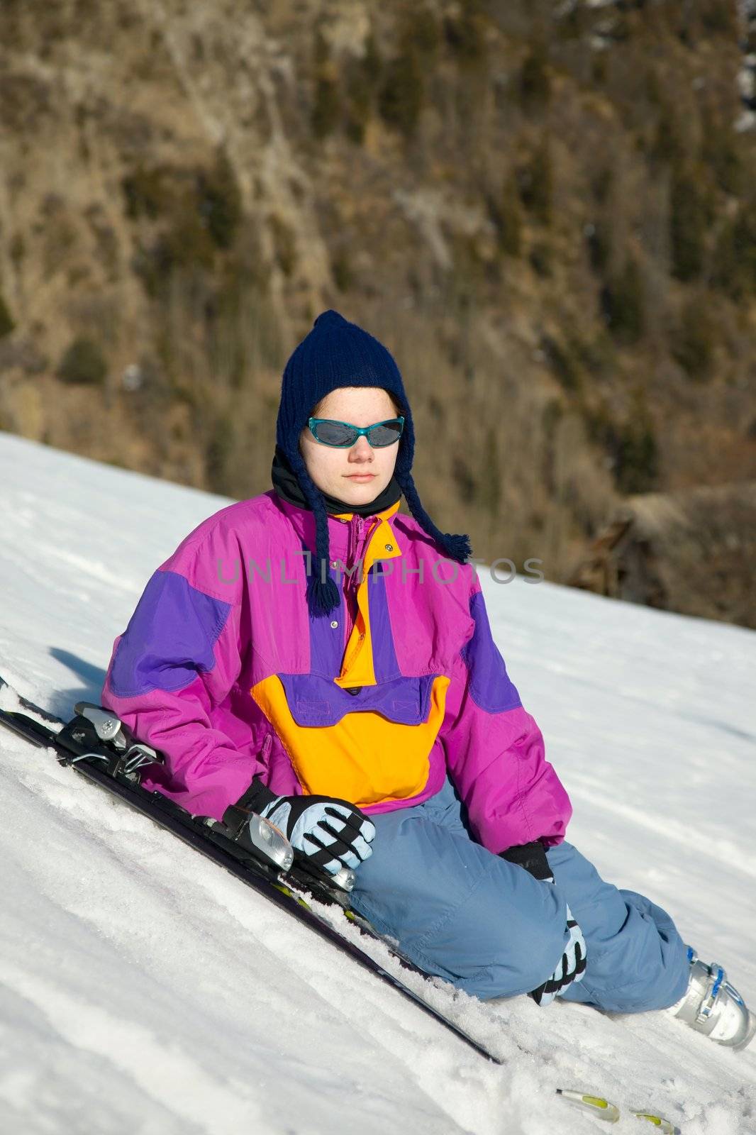 Young female skier sitting and relaxing