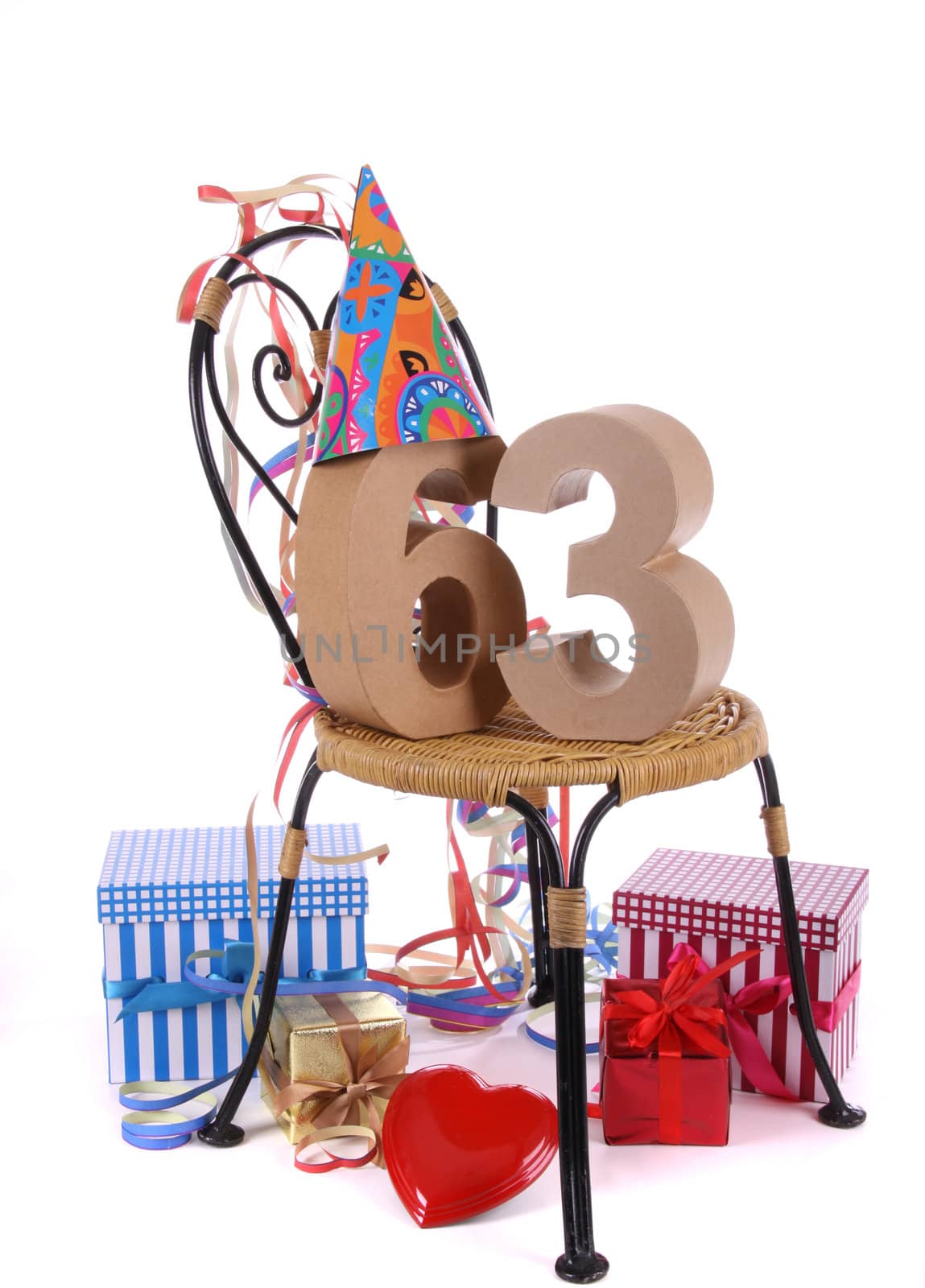 Number of age in a colorful studio setting with paper party hat and figures, a red heart and gifts