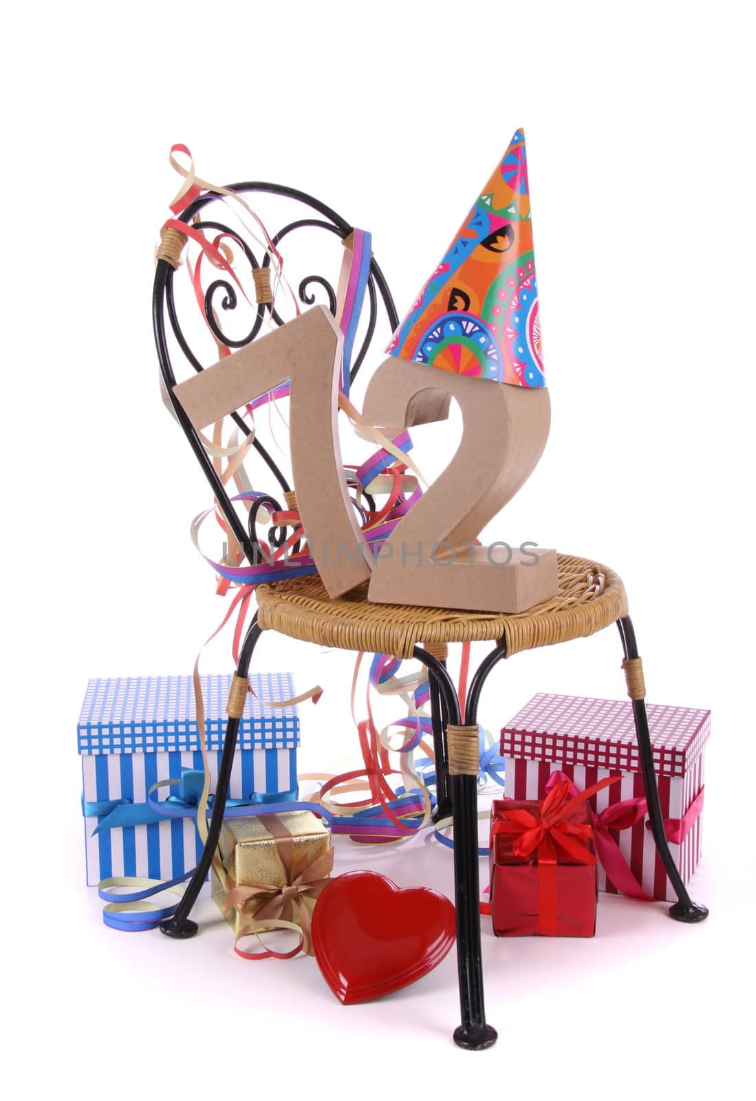 Number of age in a colorful studio setting with paper party hat and figures, a red heart and gifts