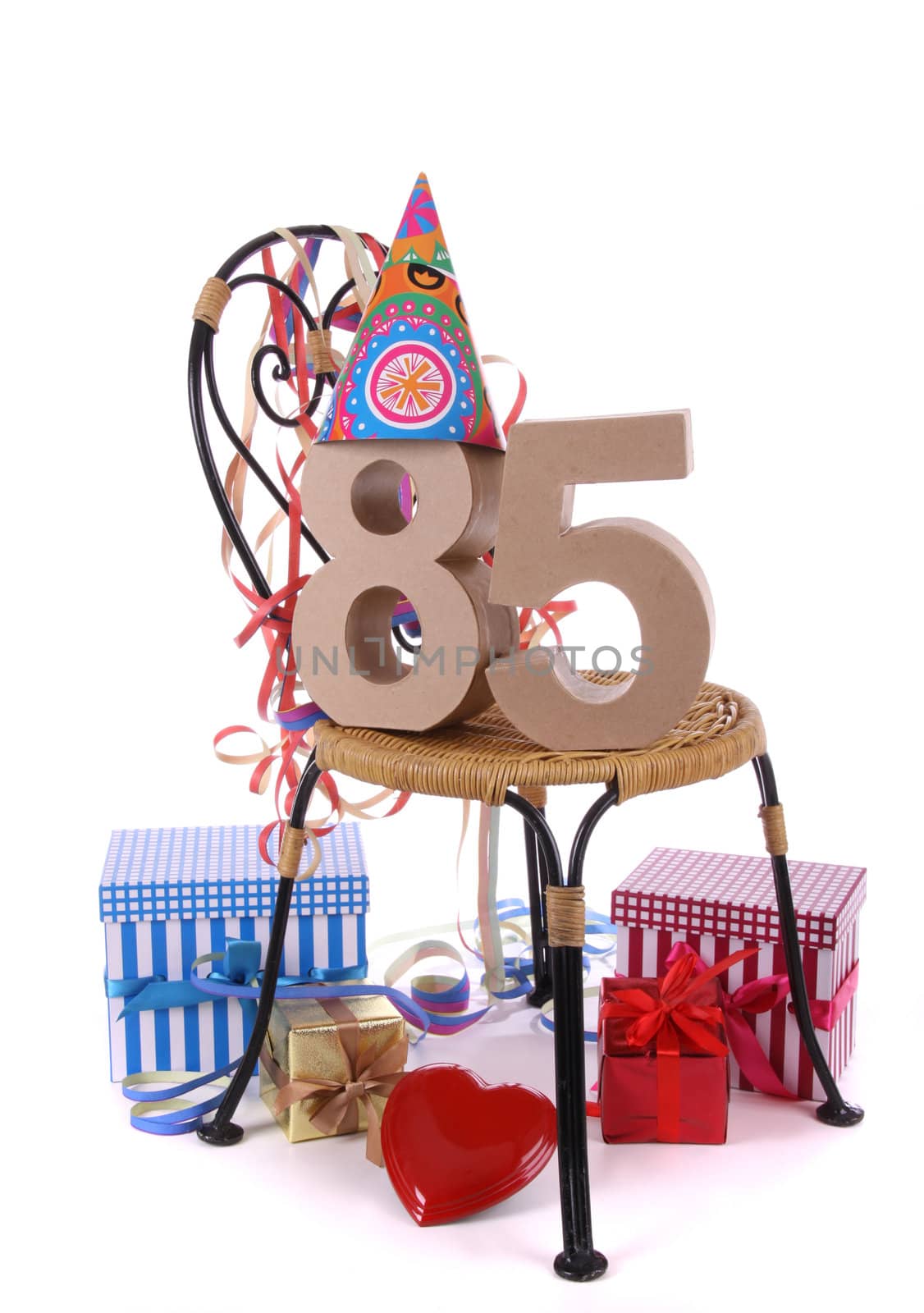 Number of age in a colorful studio setting with paper party hat and figures, a red heart and gifts