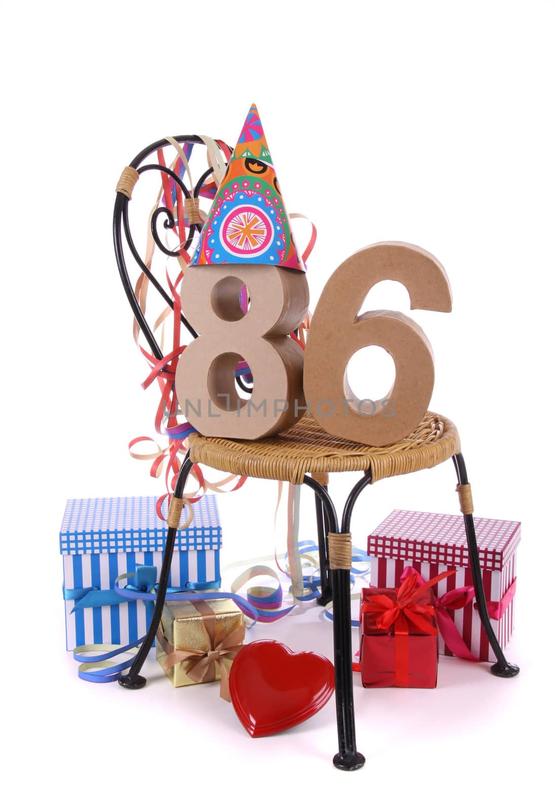 Number of age in a colorful studio setting with paper party hat and figures, a red heart and gifts