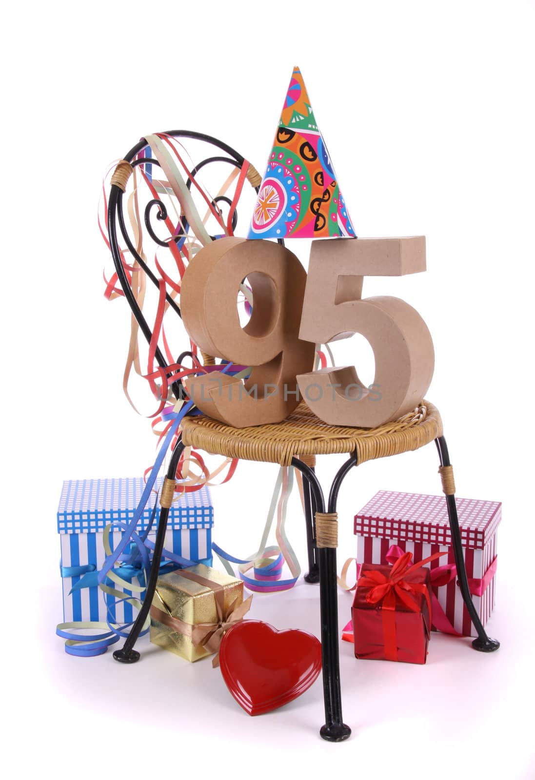 Number of age in a colorful studio setting with paper party hat and figures, a red heart and gifts