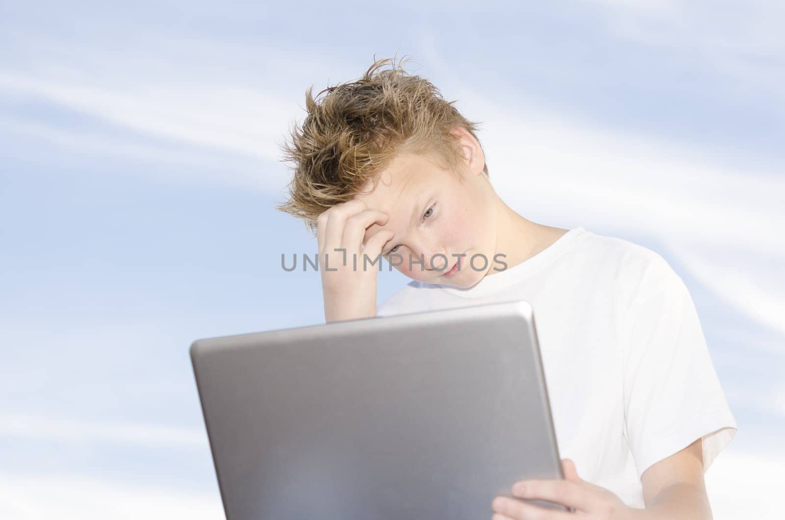 High key portrait of teenager with laptop against blue sky background