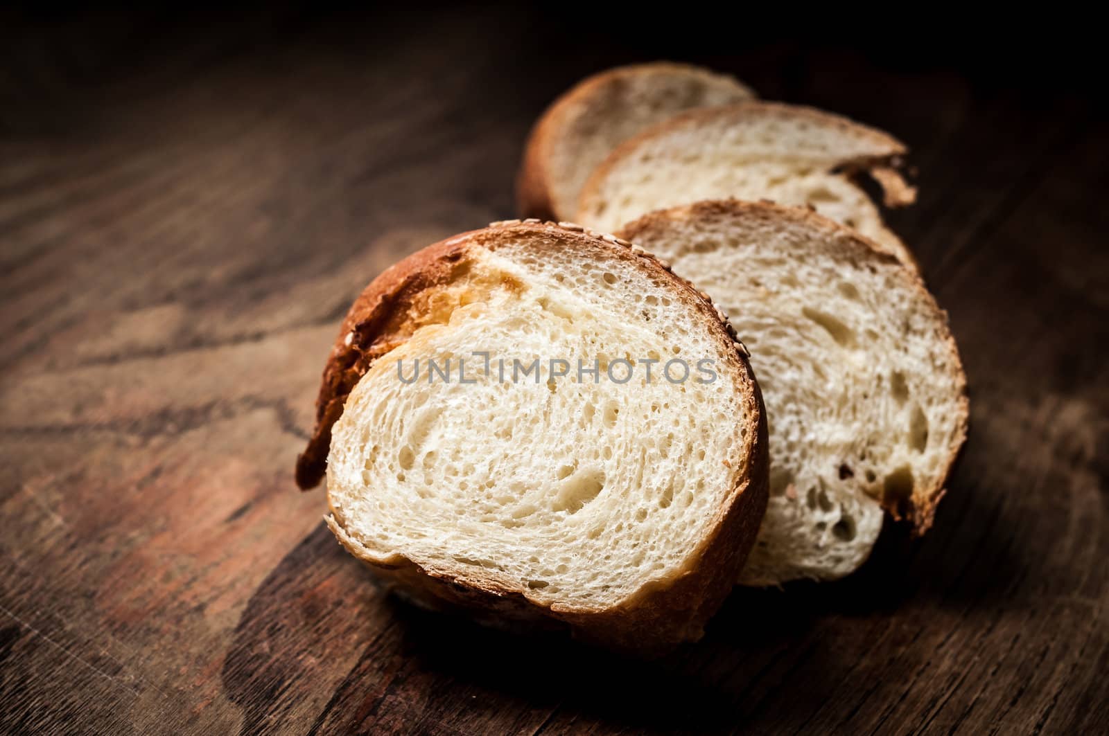 sliced wholemeal sesame bread on wood by peus