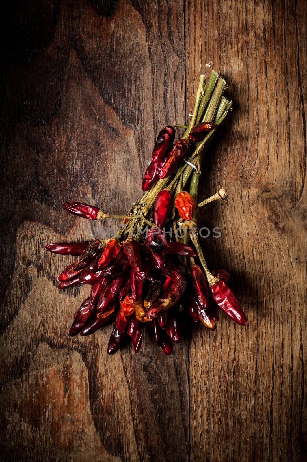 dried hot red chilies on brown textured wood