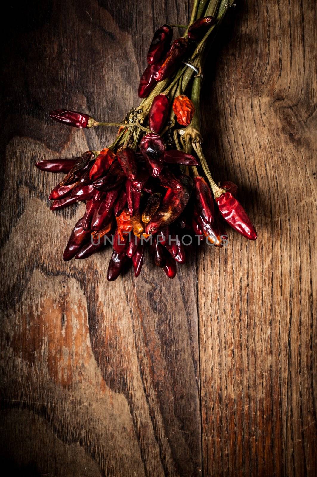 dried hot red chilies on brown textured wood