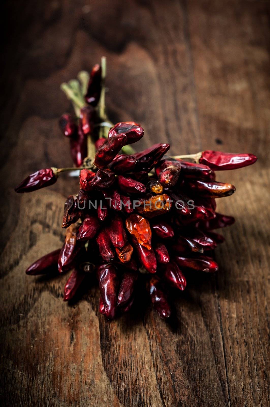 dried hot red chilies on brown textured wood