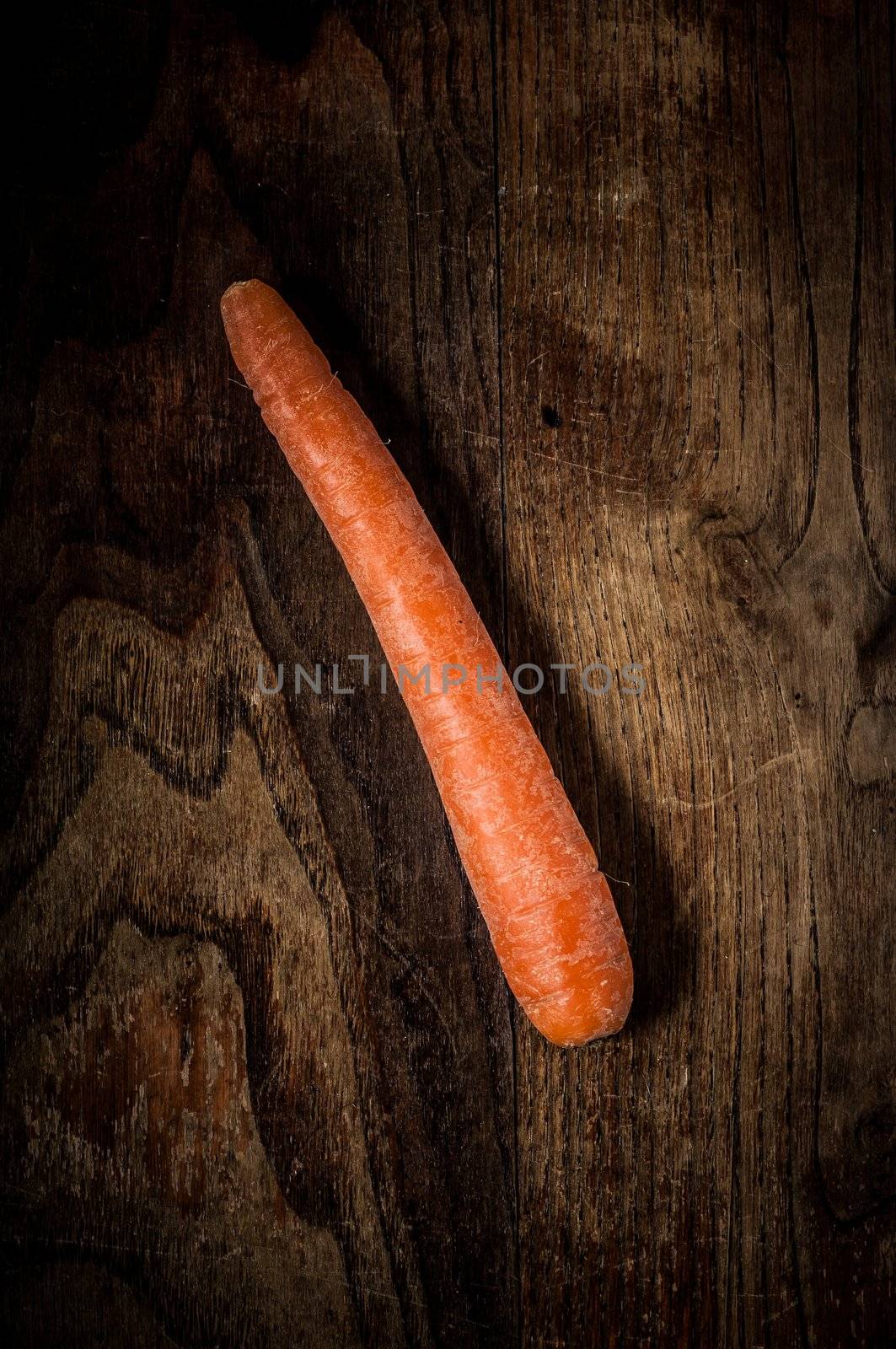 carrot on brown textured wood