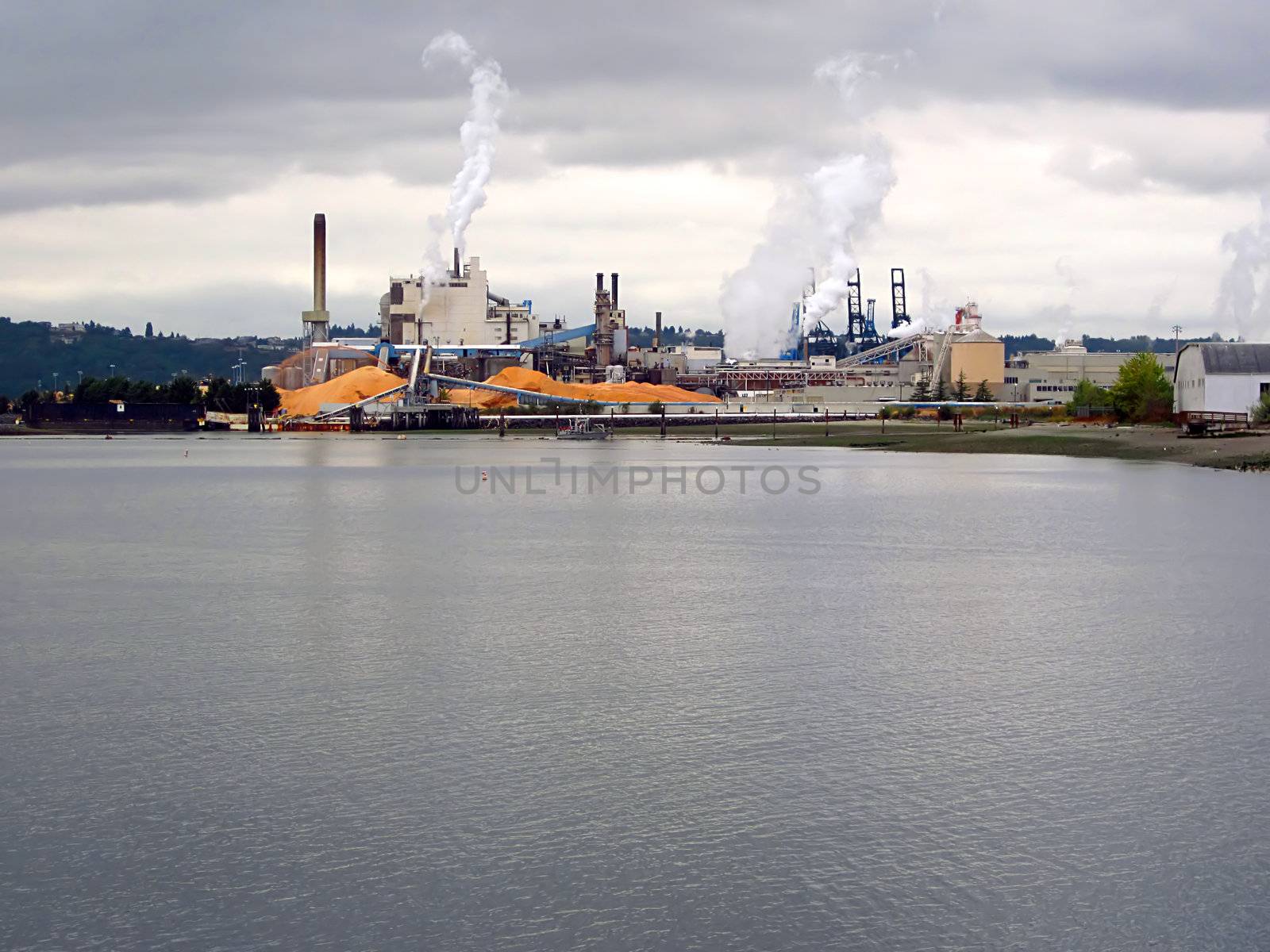 A photograph of an urban manufacturing and commerce area located near a waterway.