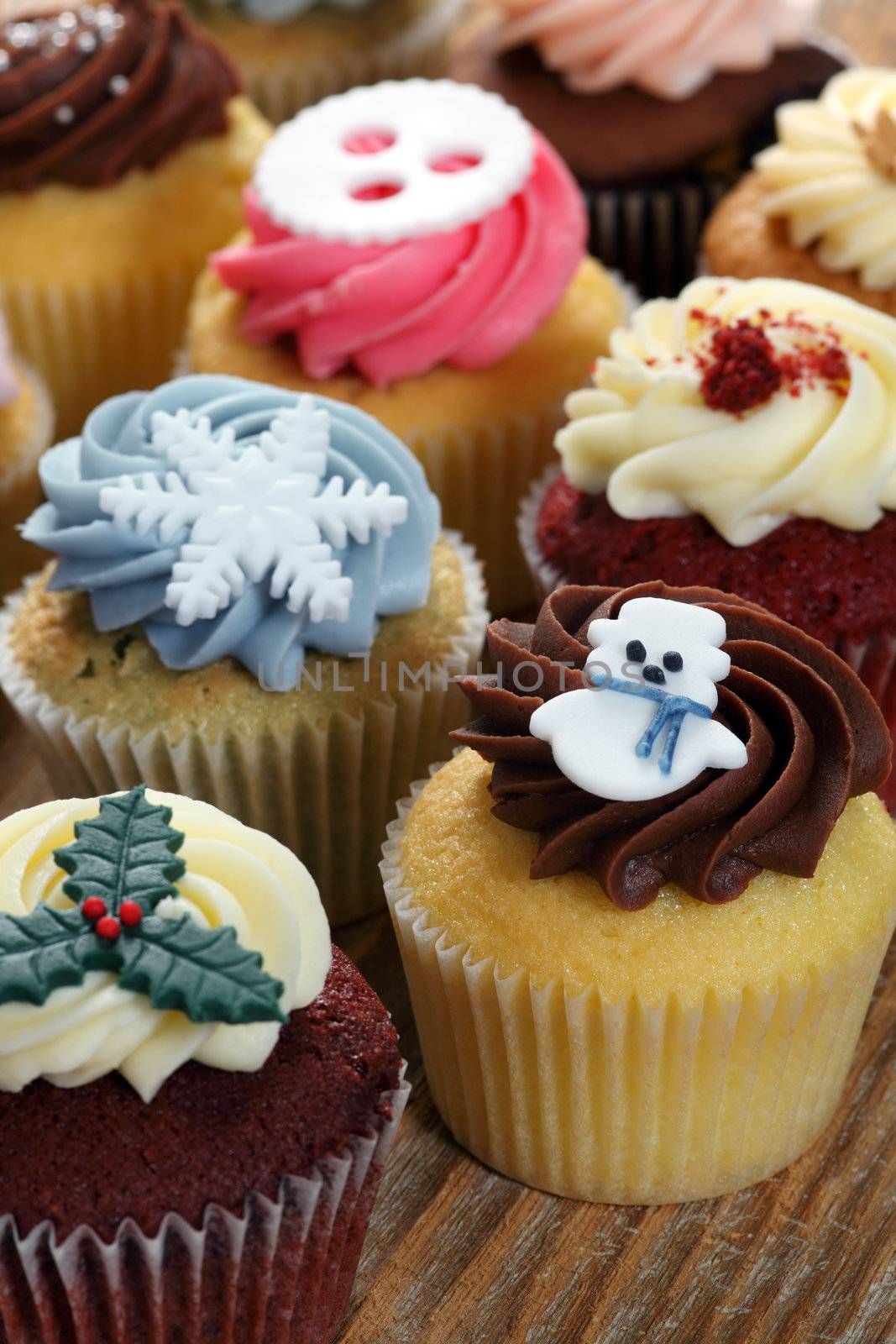 Photo of many cupcakes decorated for Christmas. Focus on snowman.