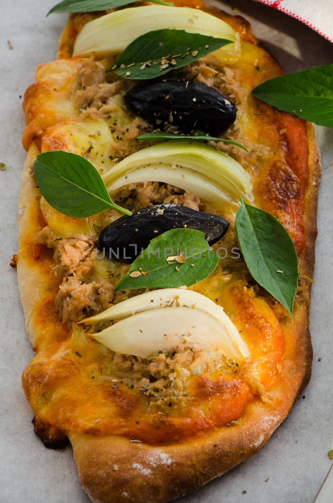 Mini homemade pizza with tuna cheese olive onion and basil on wood plate