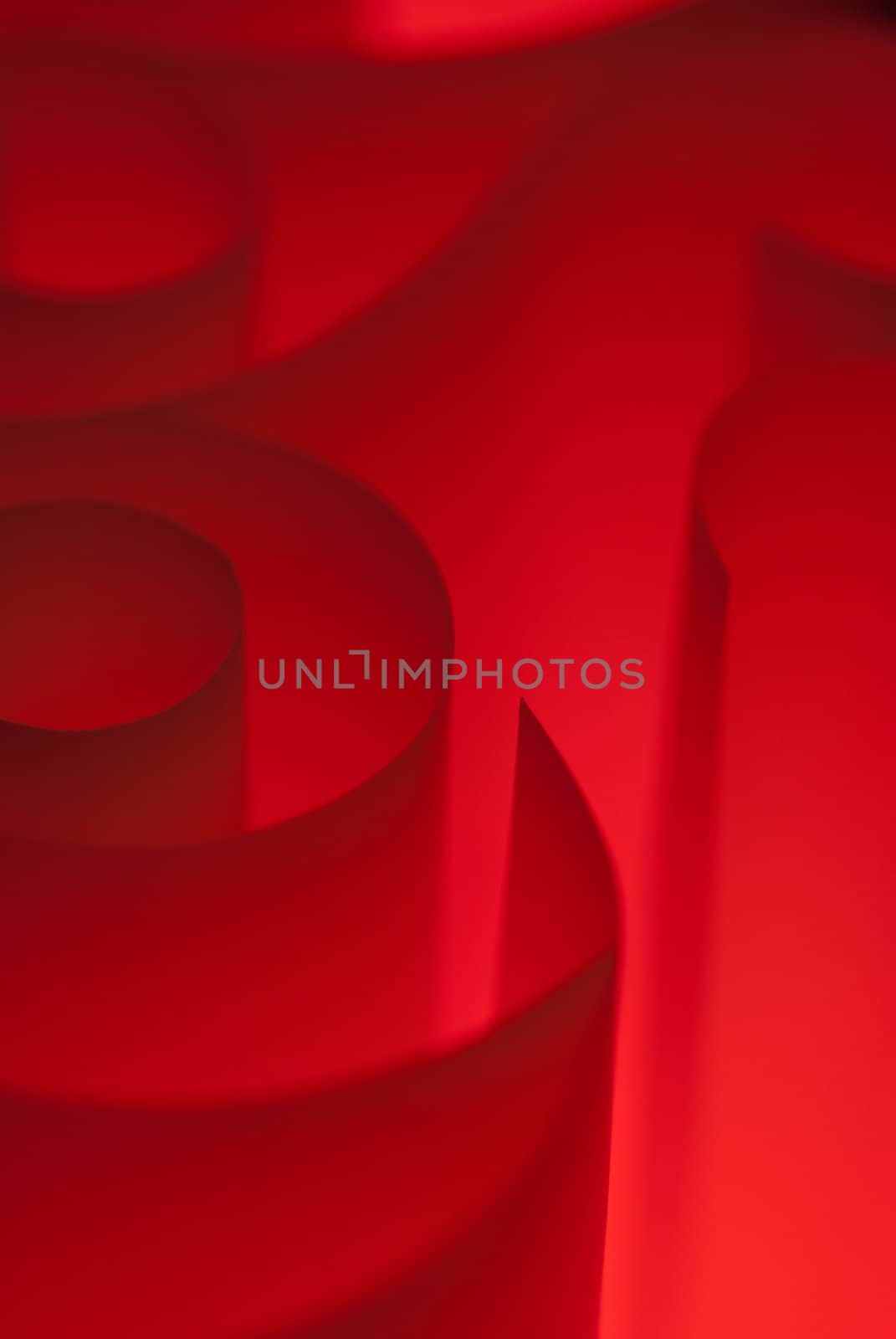 Red spirals of paper closeup lit in studio