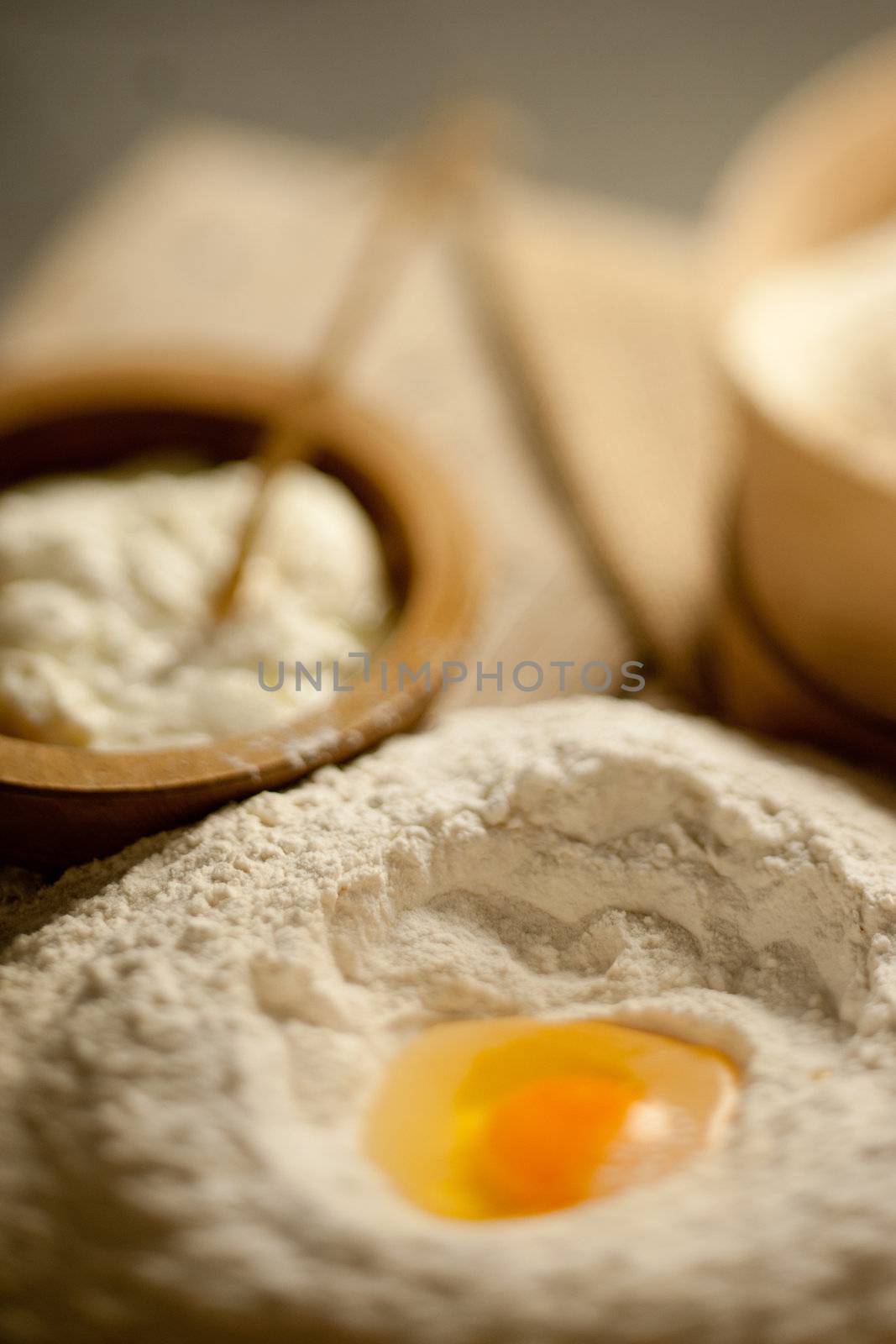 Defocused table with a heap of powder and a yolk