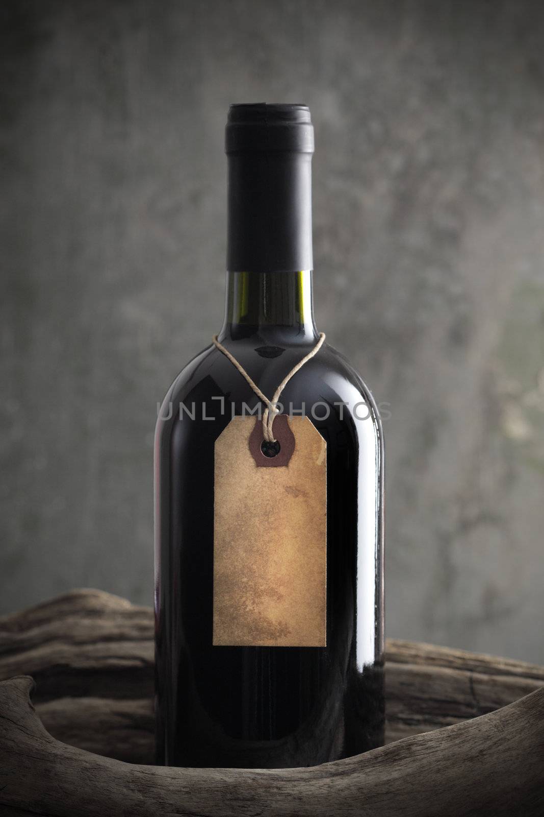 Red wine bottle with old paper label by stokkete
