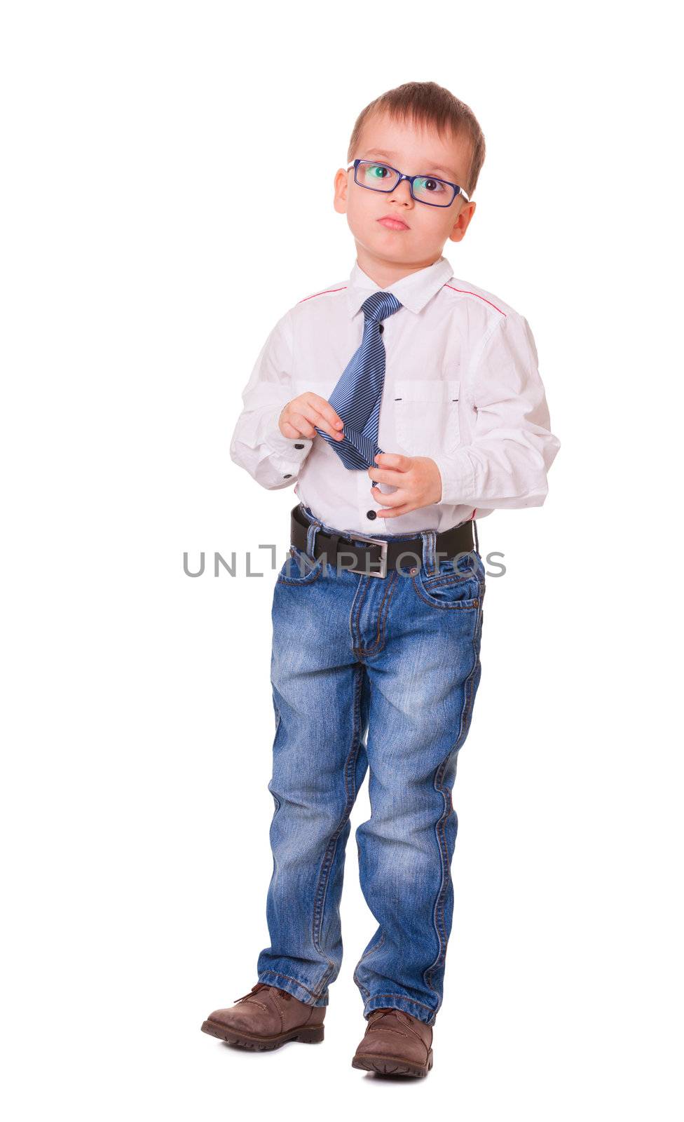 Full-length upset small boy in glasses, jeans and white shirt isolated on white background