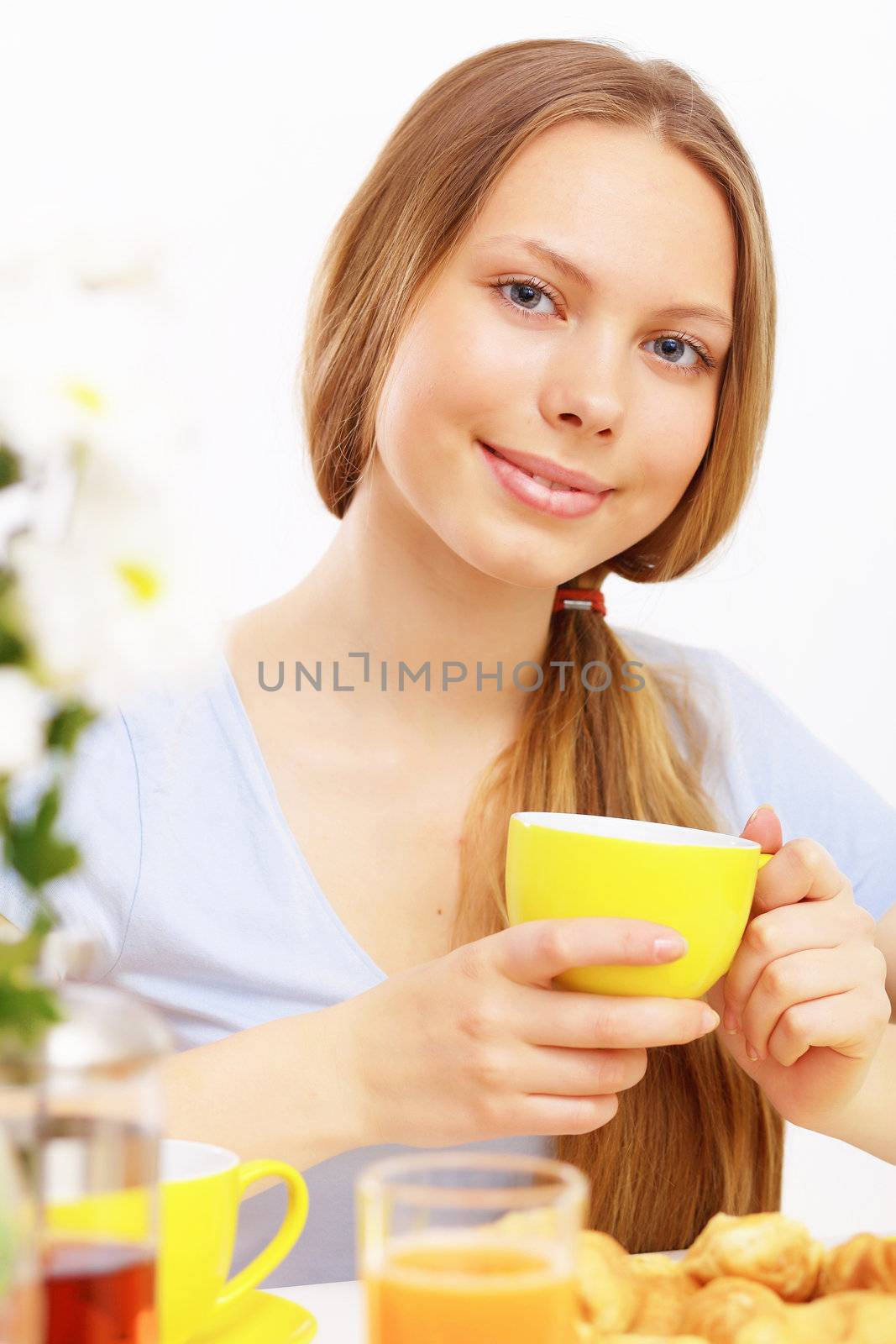 Beautiful young woman drinking tea from yellow cup