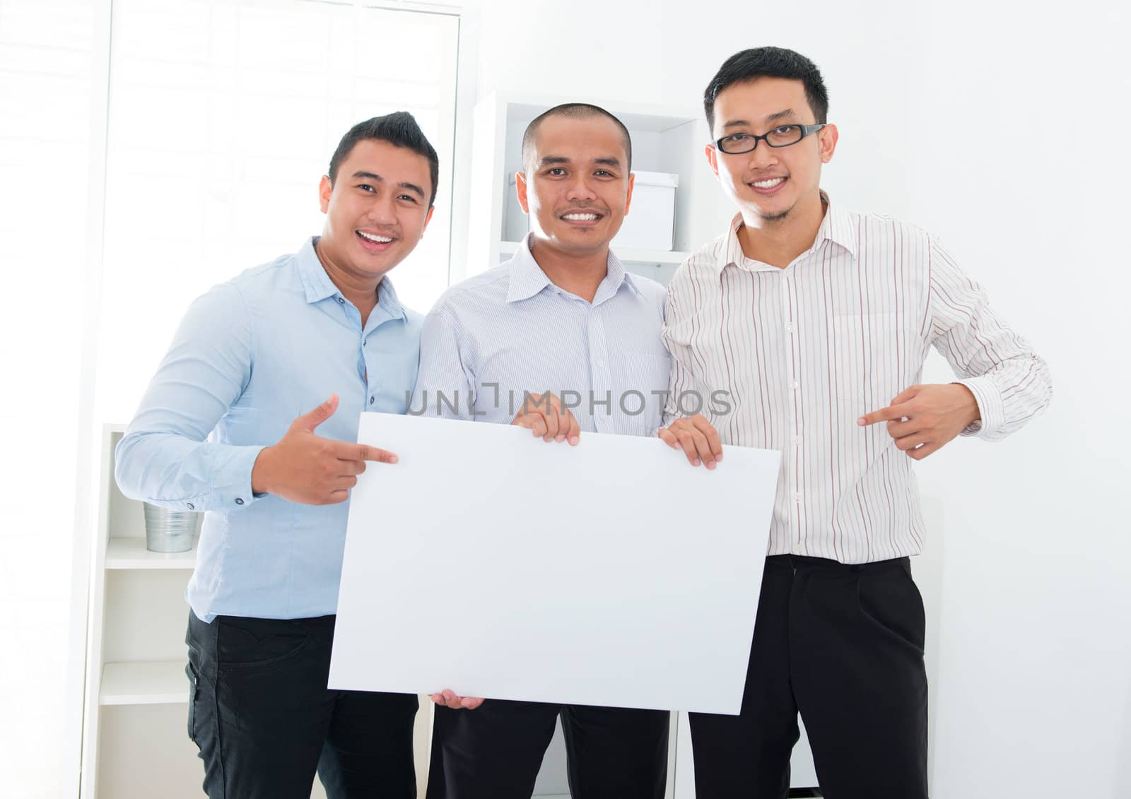 Asian business team holding a blank banner by szefei