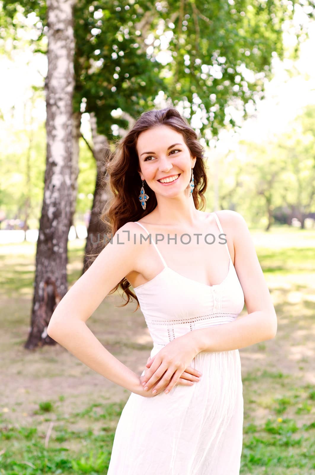 Portrait of an attractive woman in the park, smiling and happy