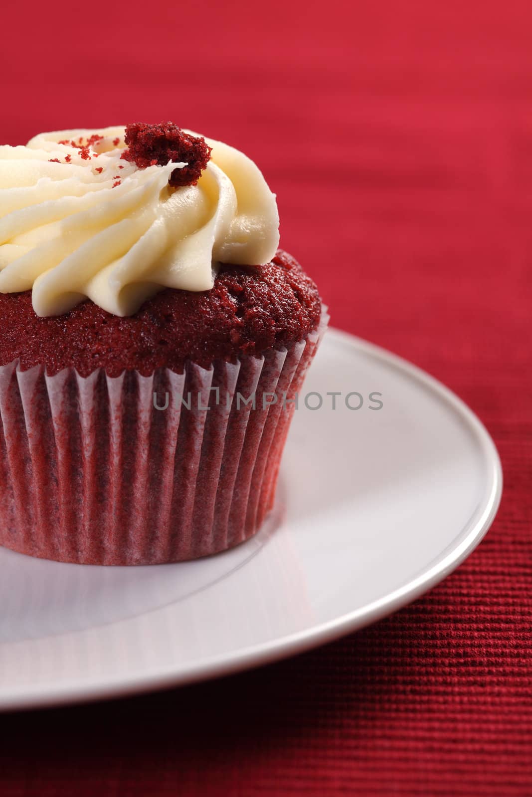 Photo of a cupcake resting on a white plate.