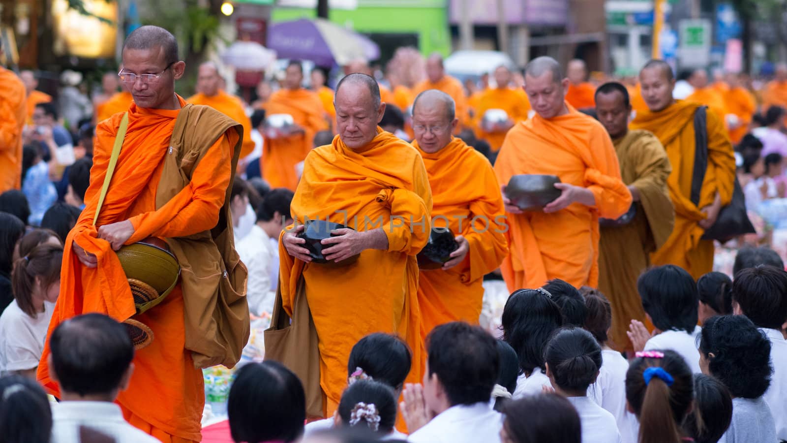 BANGKOK - DECEMBER 23: Monks participating in a mass alms giving in the morning at Soi Thonglor in celebration of the 2,600th anniversary of Lord Buddha's enlightenment on December 23, 2012 in Bangkok, Thailand.