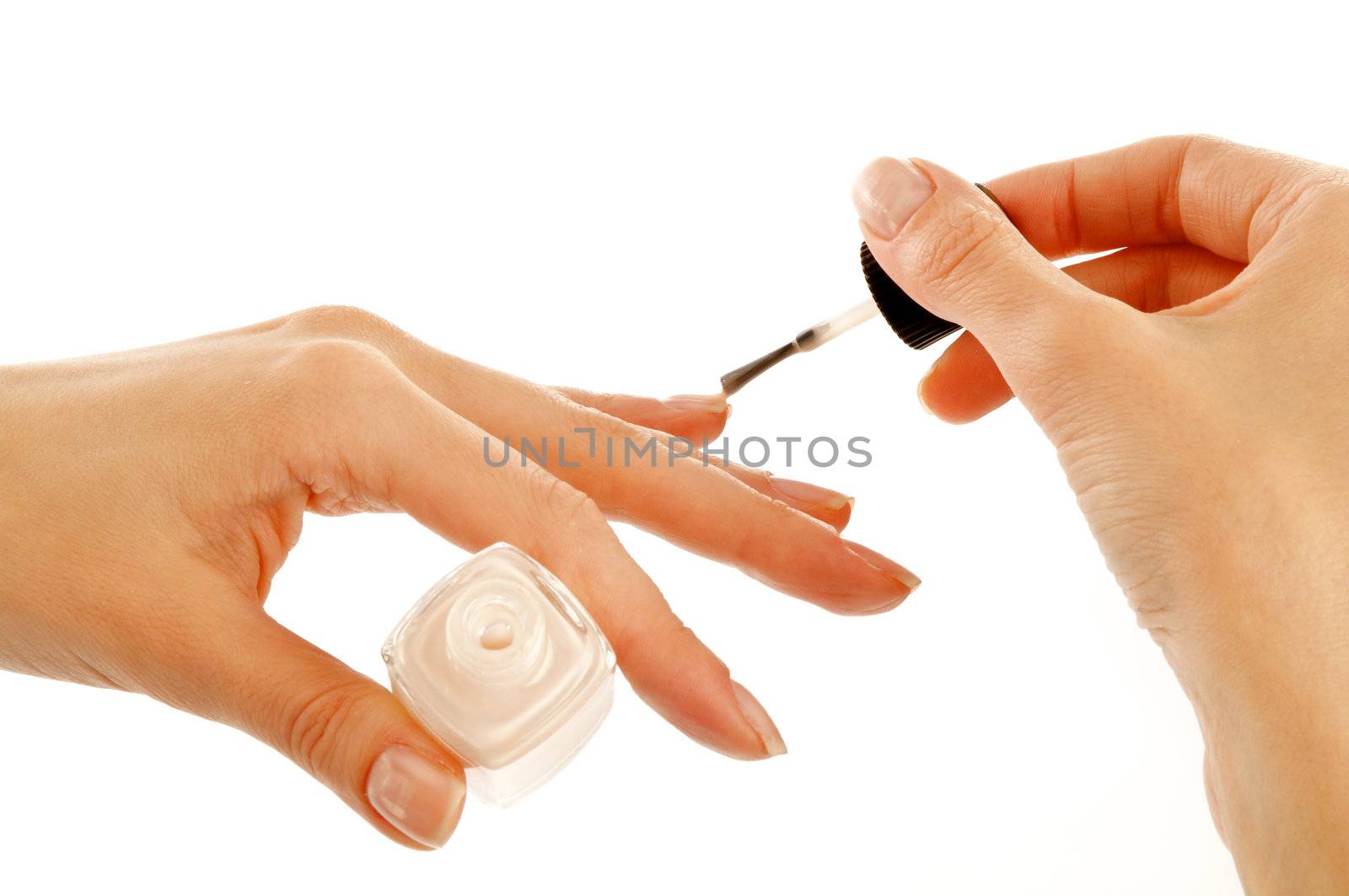 Woman's Hands Painting Flesh Colour Nail Polish isolated on white background