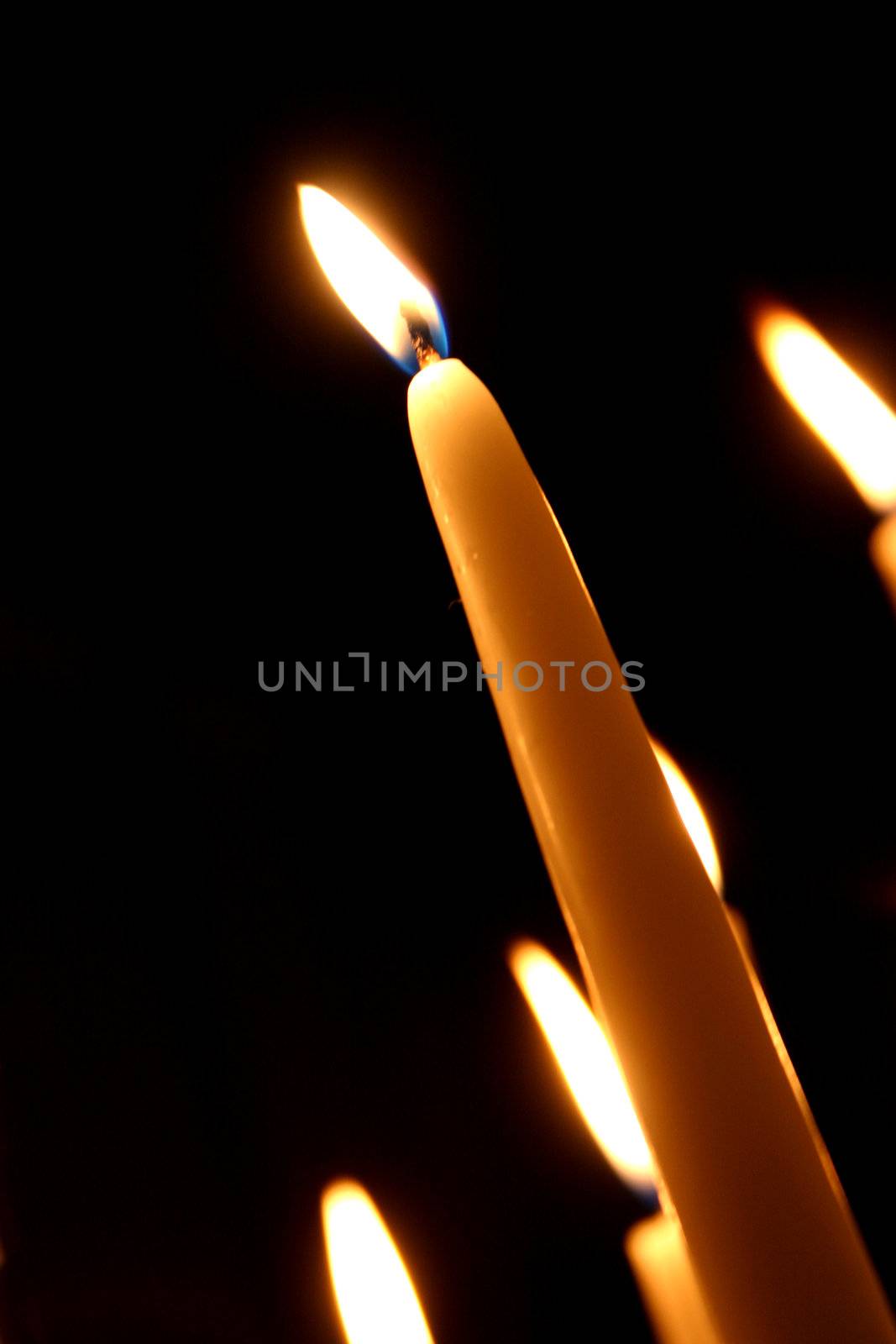 White candle on black background in a church